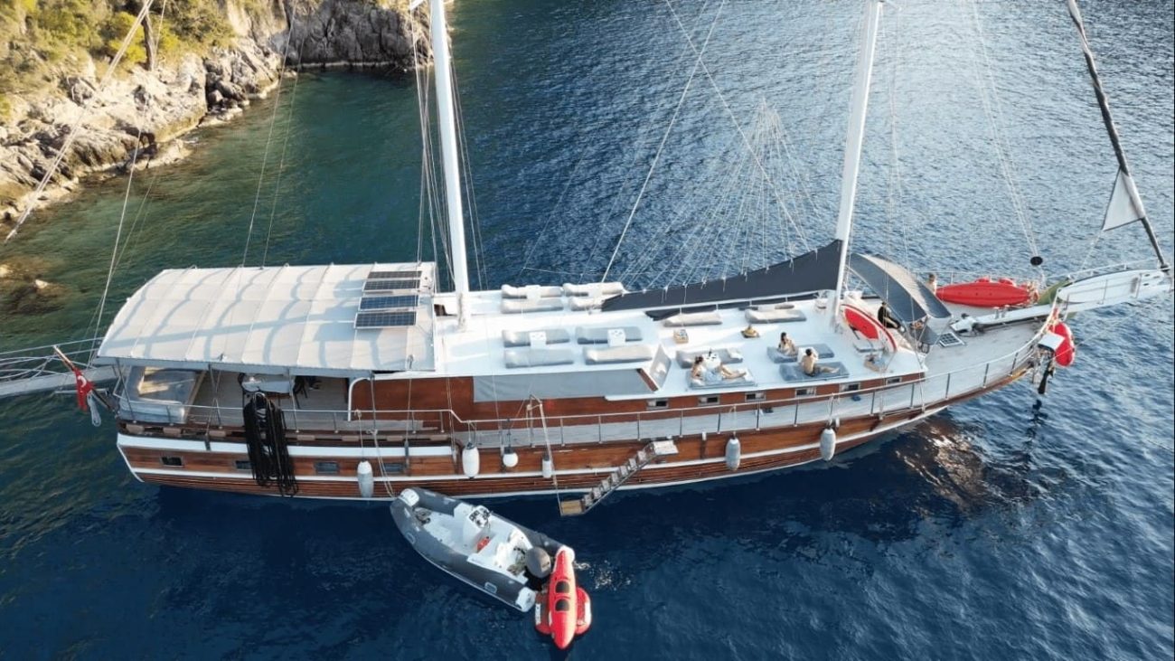 A traditional wooden Turkish gulet boat sailing on turquoise Mediterranean waters.